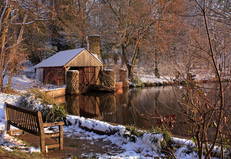 Snowy pond with wooden hut