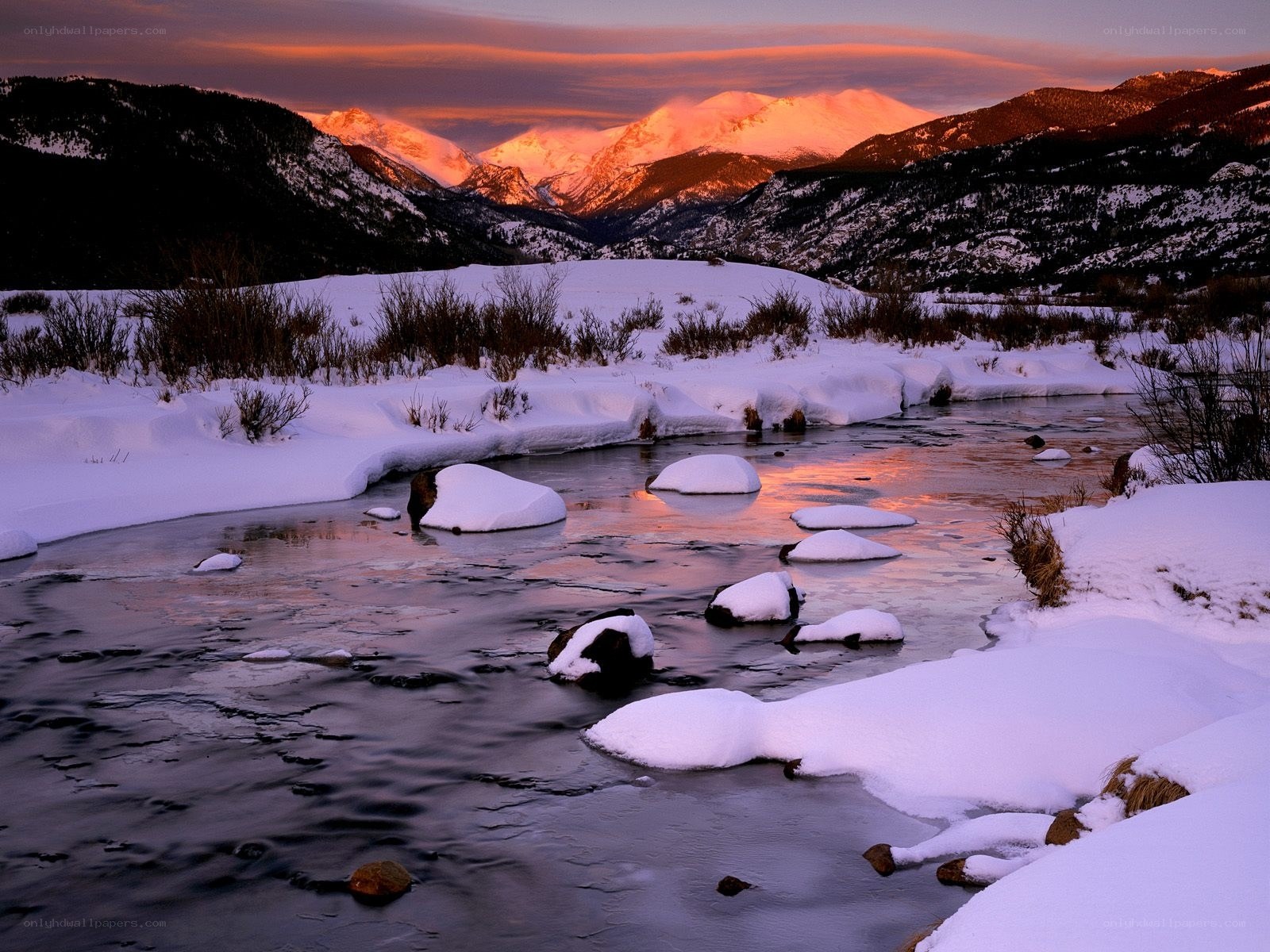 Snowy river at sunset in mountains