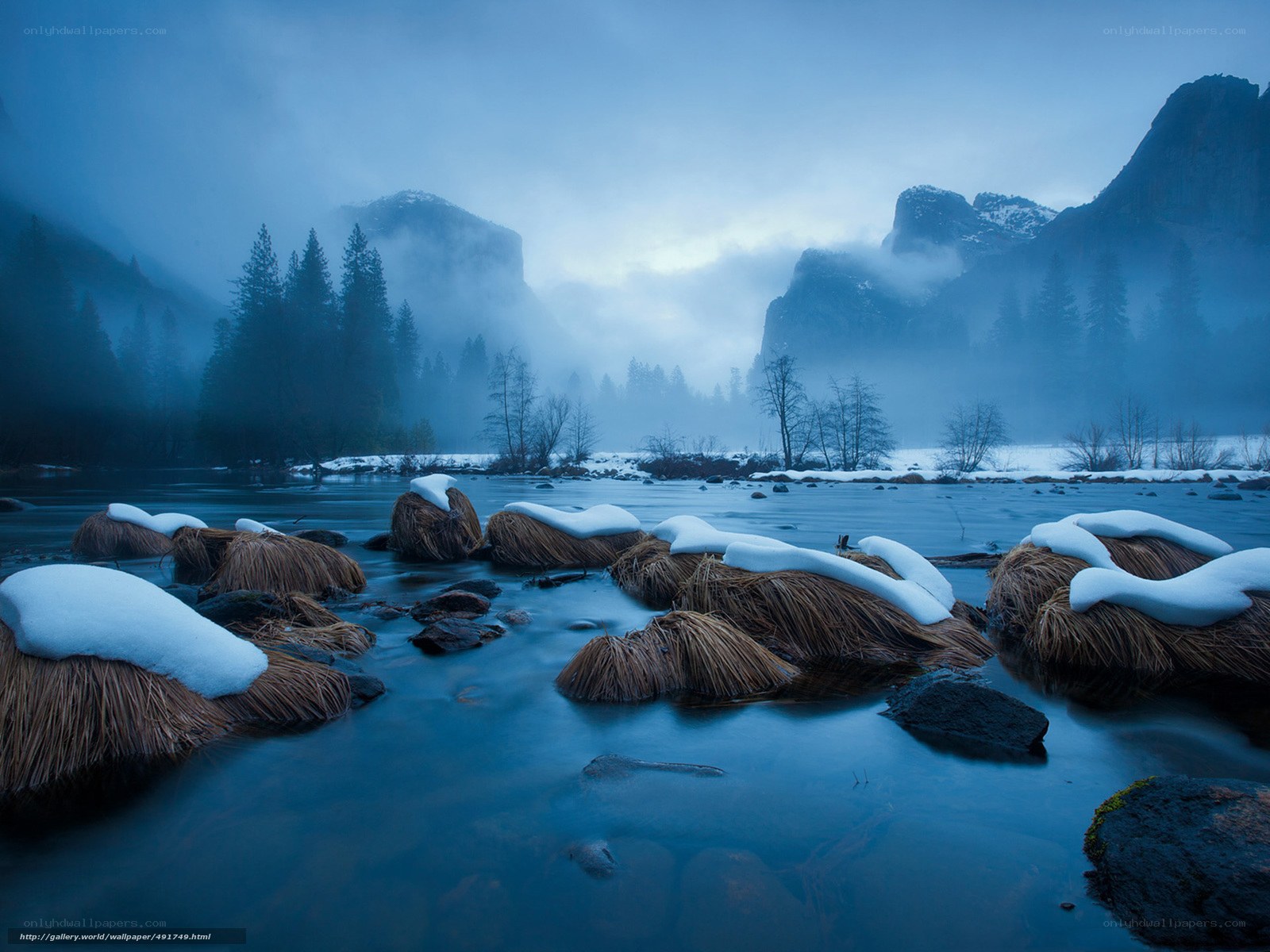 Snowy river in misty valley