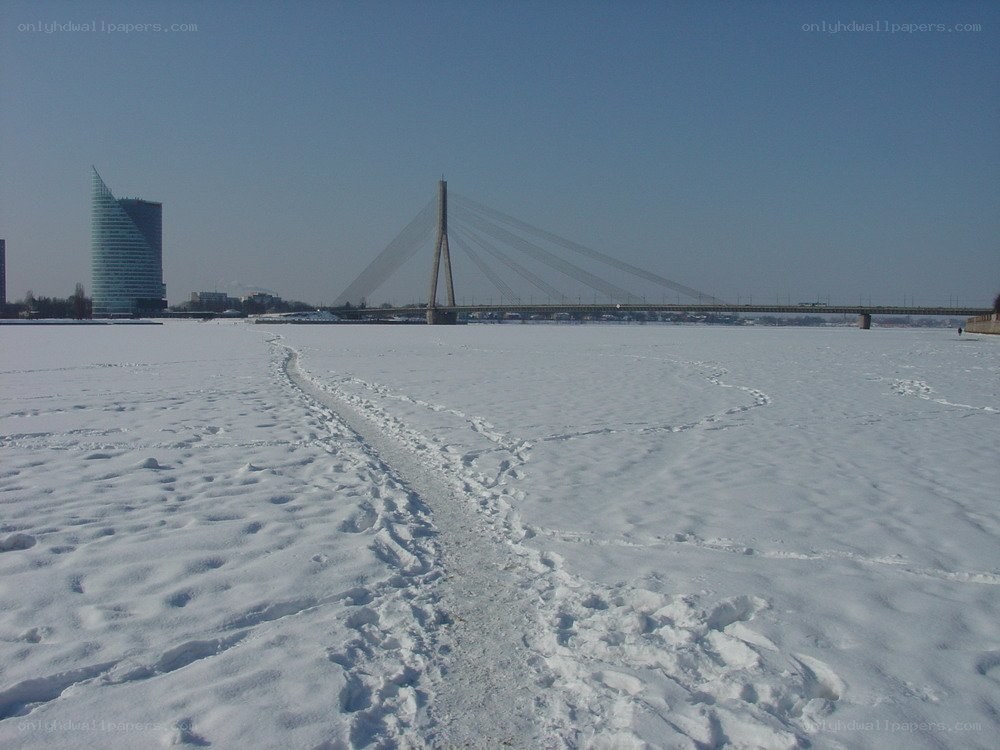 Snowy river with bridge and building