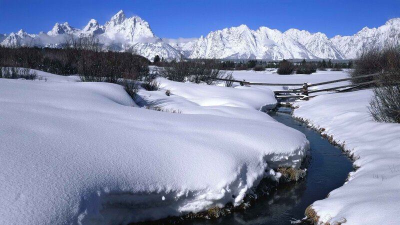 Snowy river with mountain backdrop