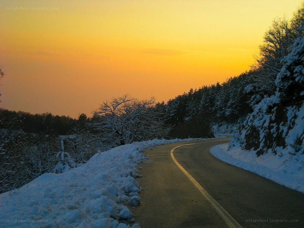 Snowy road at sunset
