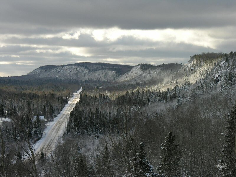 Snowy road through forested hills