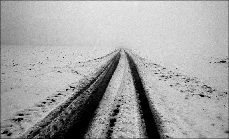 Snowy road tracks in fog
