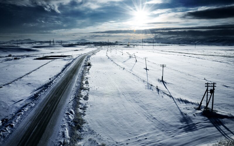Snowy road under bright sun