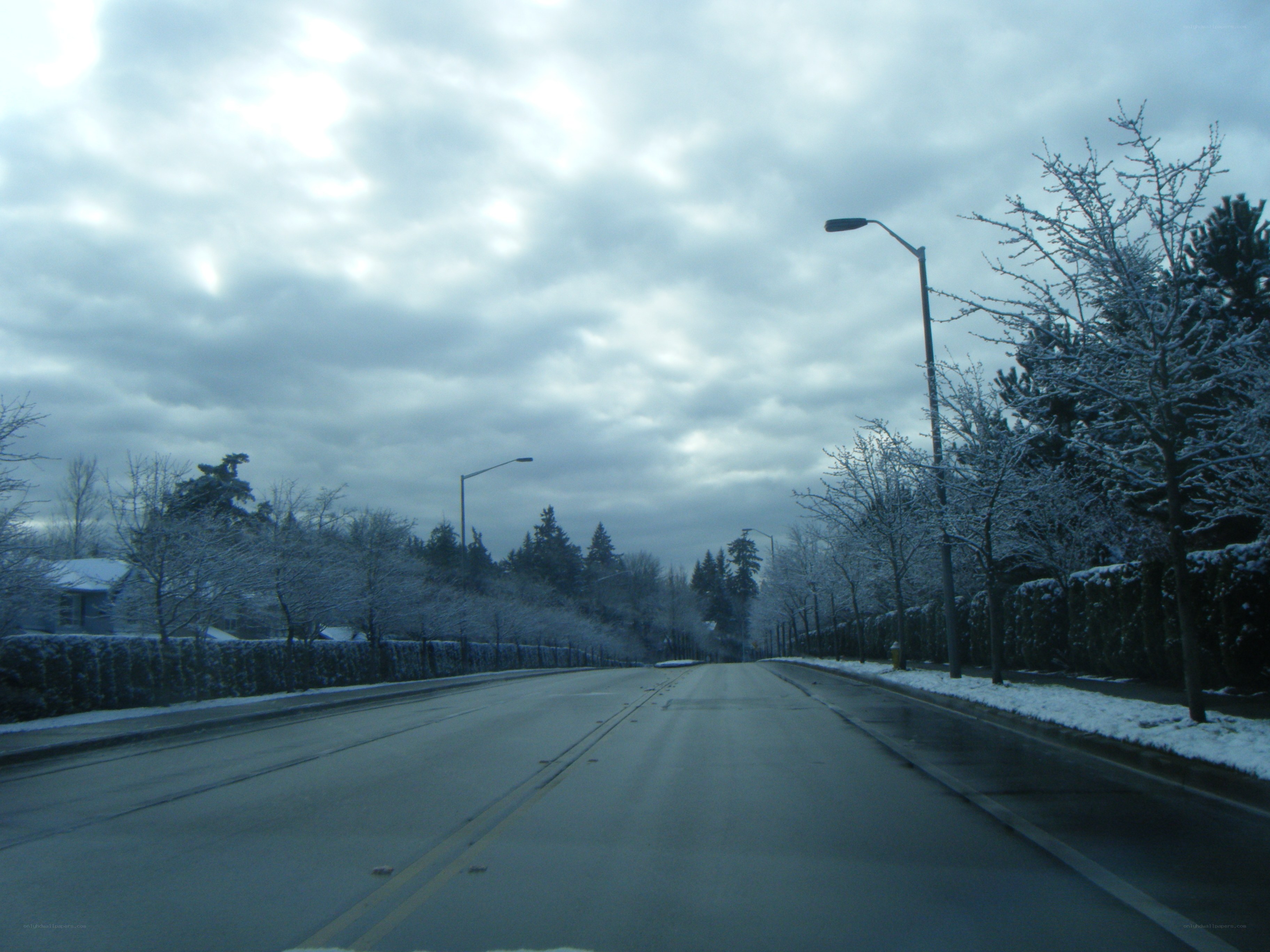 Snowy road under cloudy sky