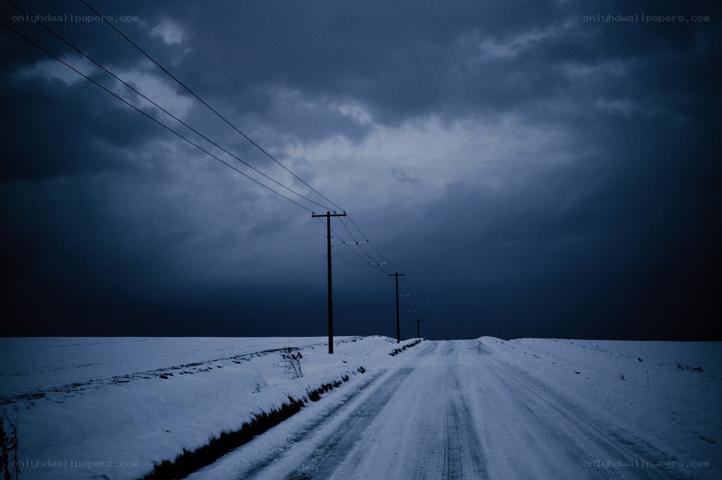 Snowy road under dark sky