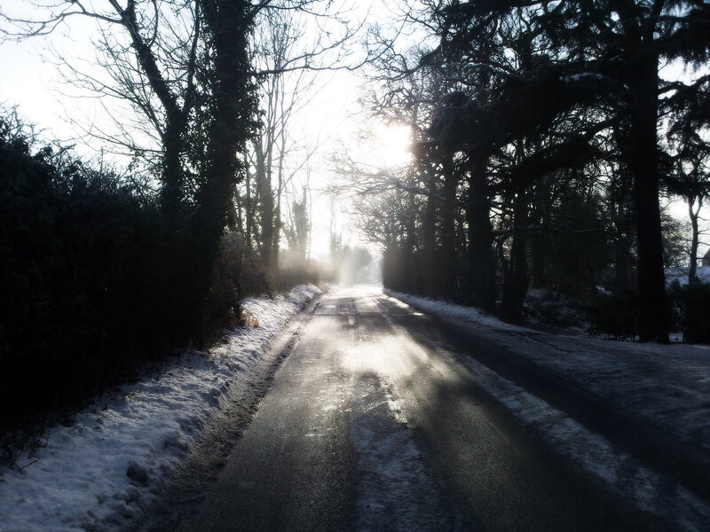 Snowy road with sun glare