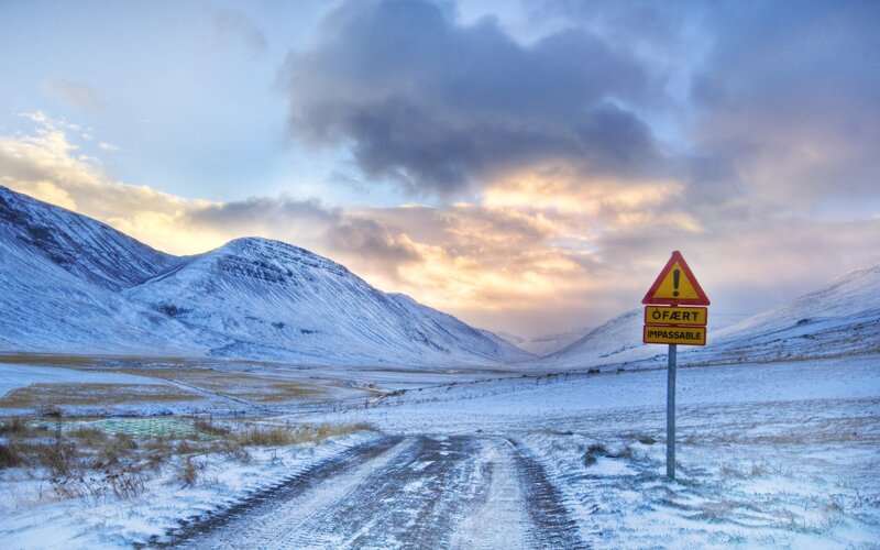 Snowy road with warning sign