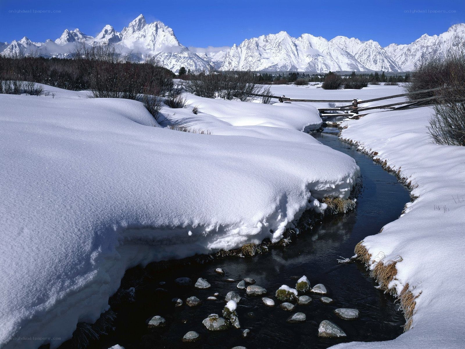 Snowy stream with mountain backdrop