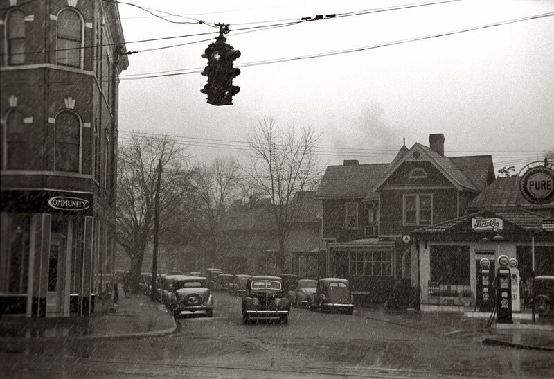 Snowy street scene with vintage cars