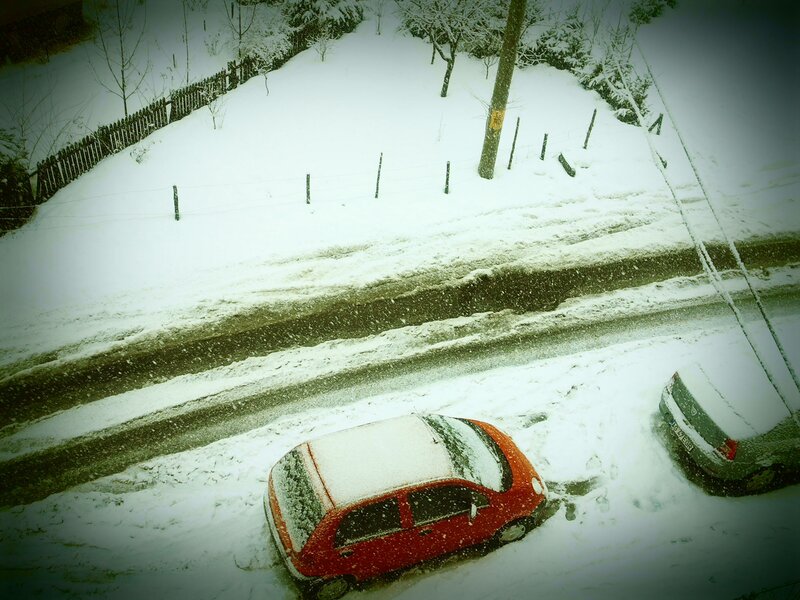 Snowy street with parked cars