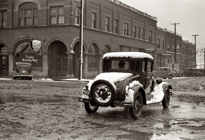 Snowy street with vintage cars