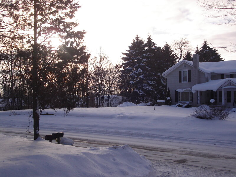 snowy suburban street at sunset