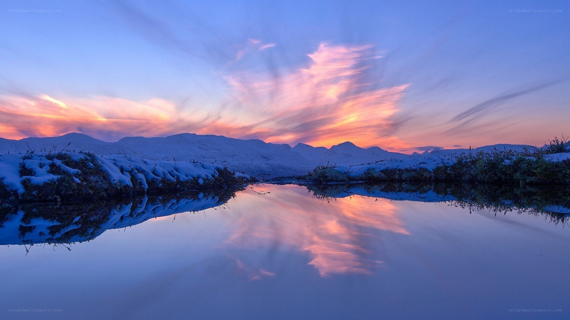 Snowy sunset over a calm lake