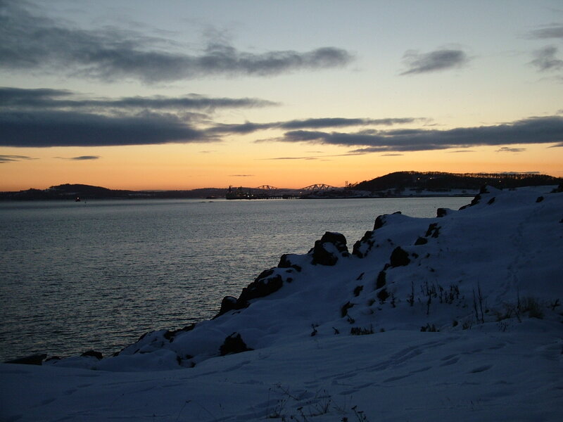 Snowy sunset over a coastal bay
