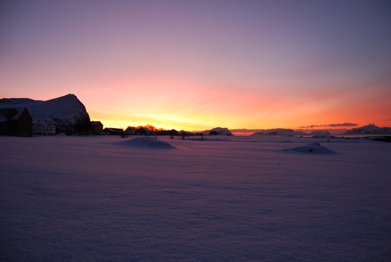 Snowy sunset over a coastal village