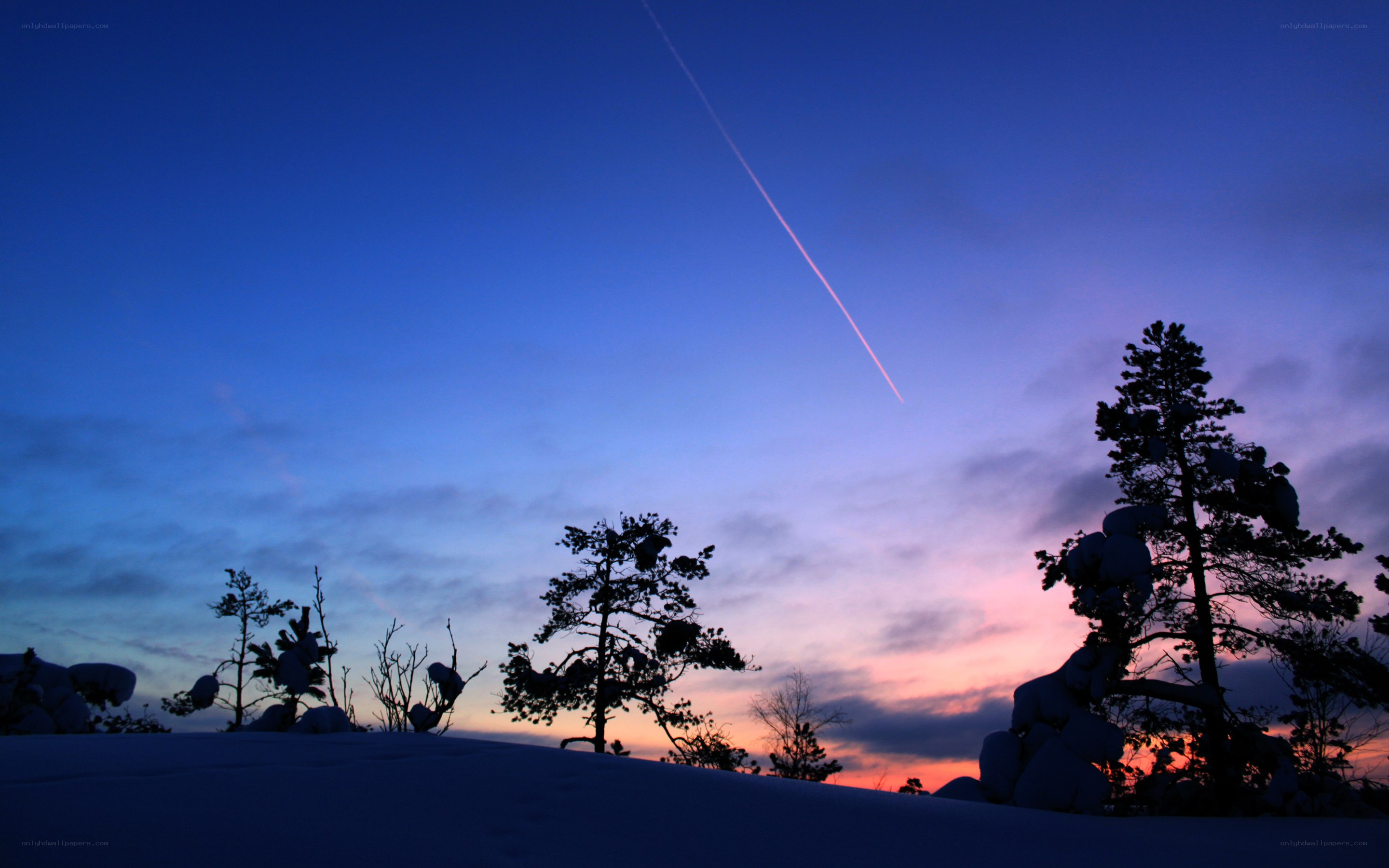 Snowy sunset with contrail