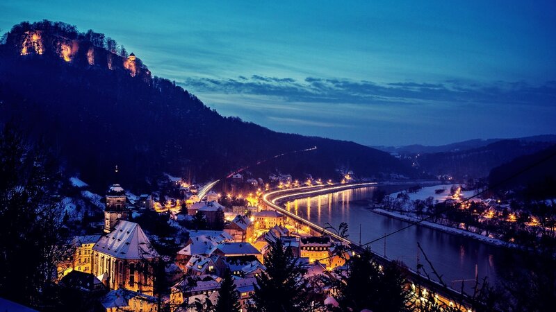 snowy town at dusk by the river
