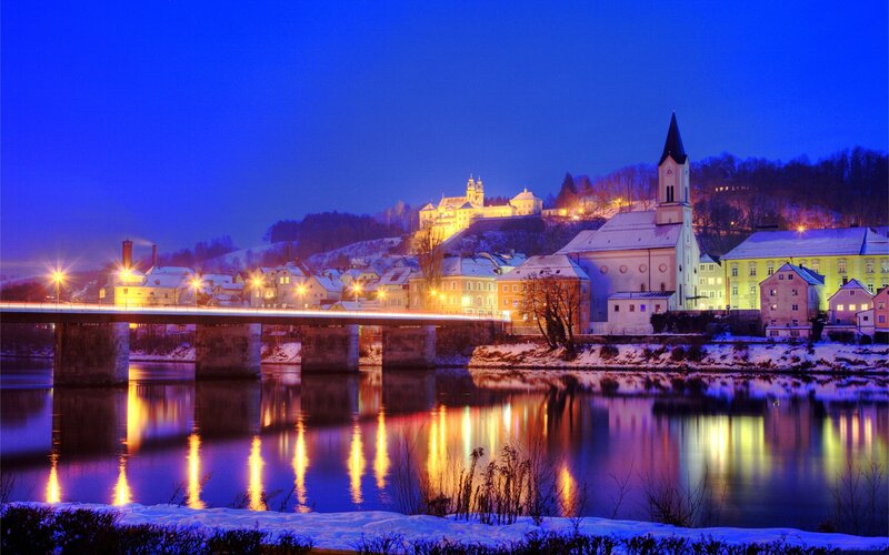 Snowy town at night by the river