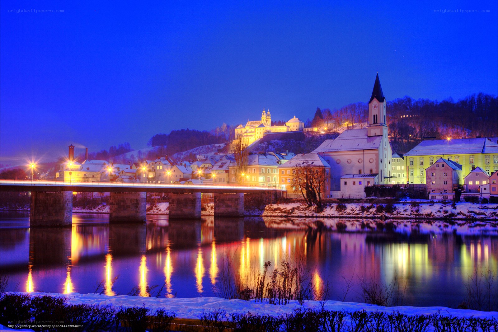 Snowy town at night by the river