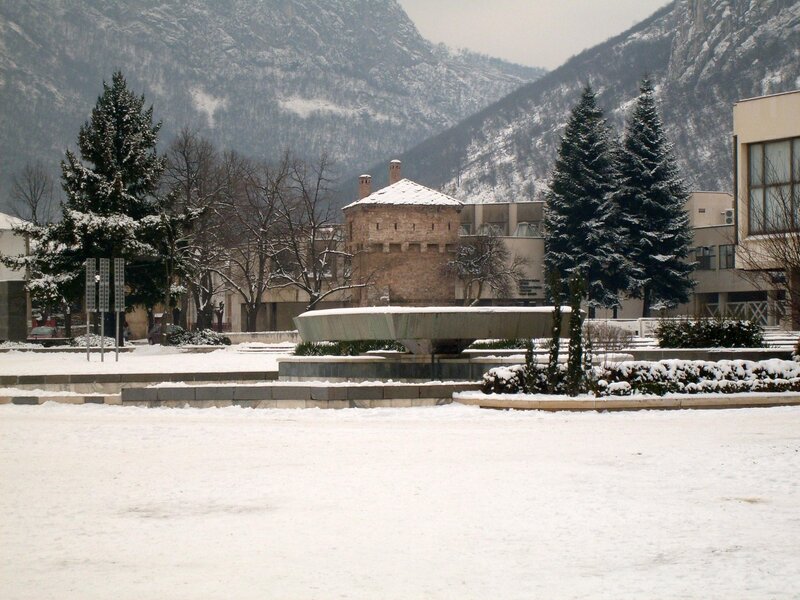 Snowy town square with mountain backdrop