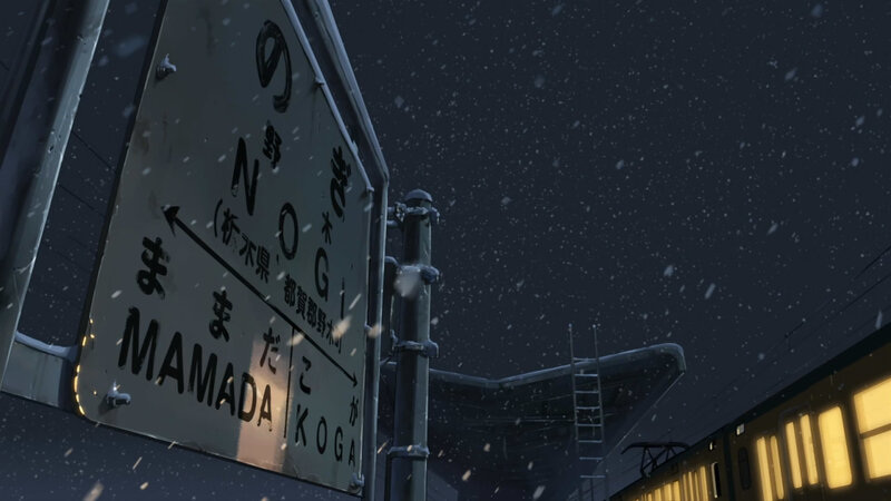 Snowy train station sign at night