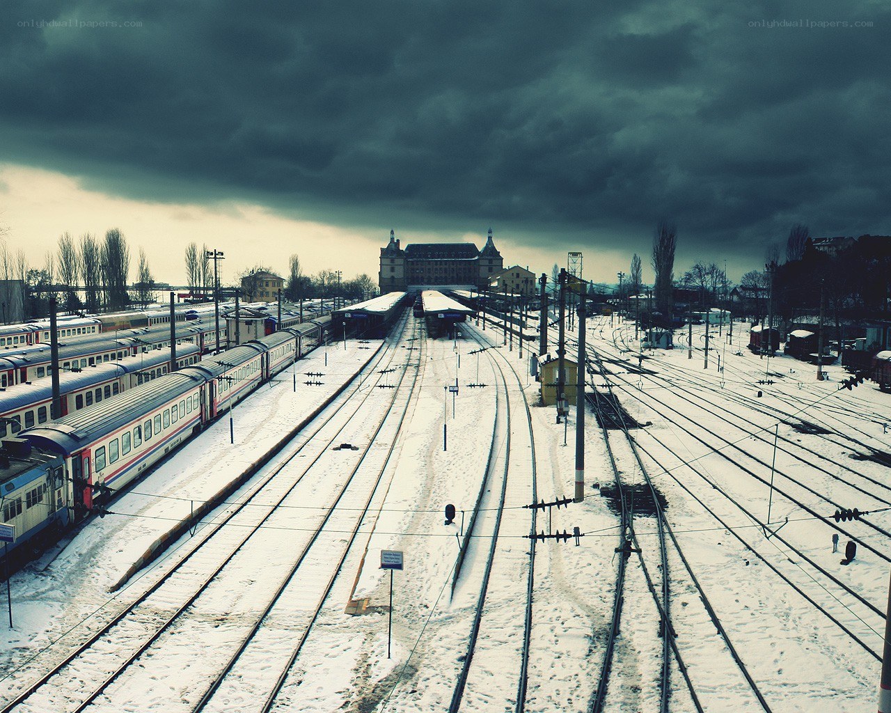 Snowy train station under stormy sky