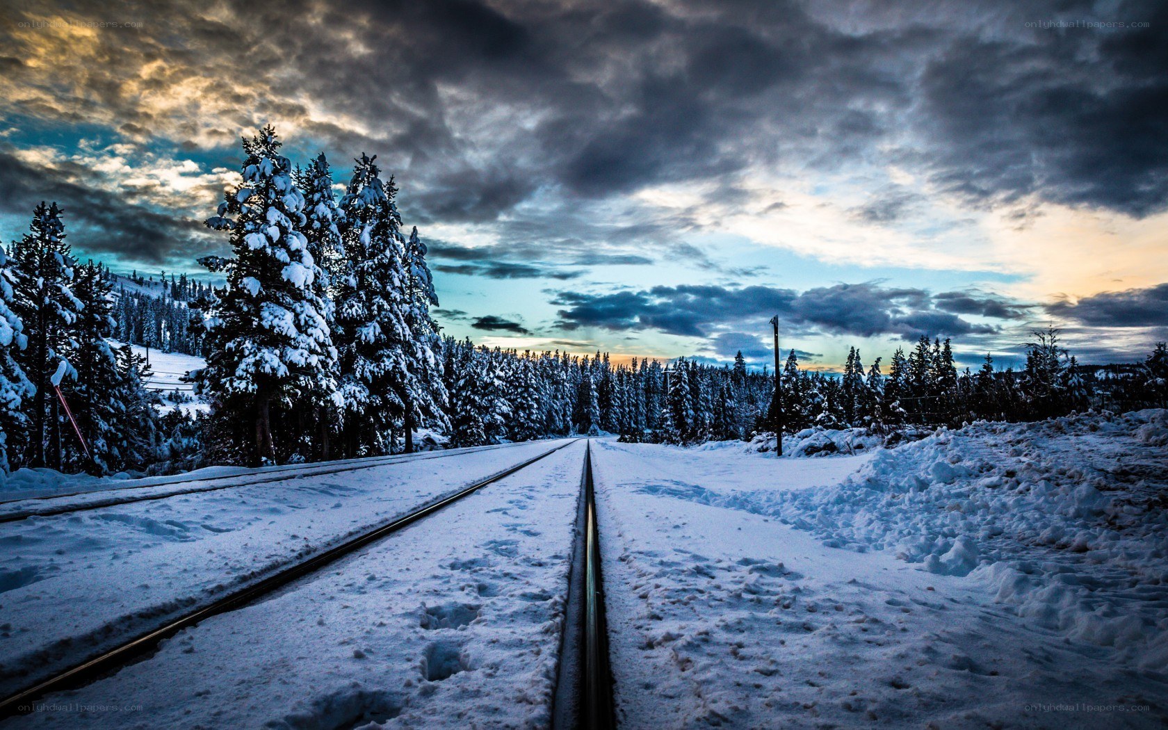 Snowy train tracks at dusk