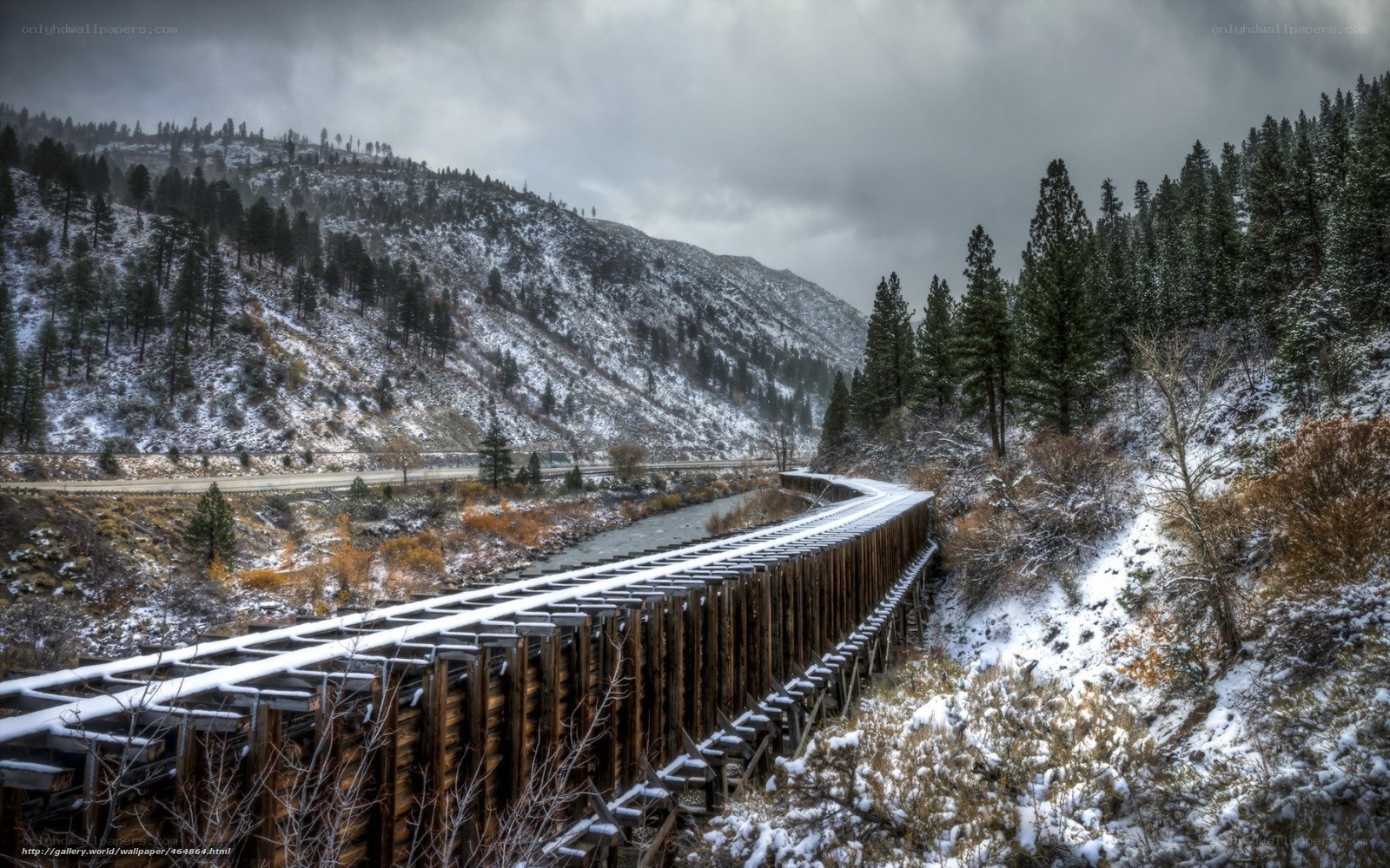 Snowy train trestle in mountain valley