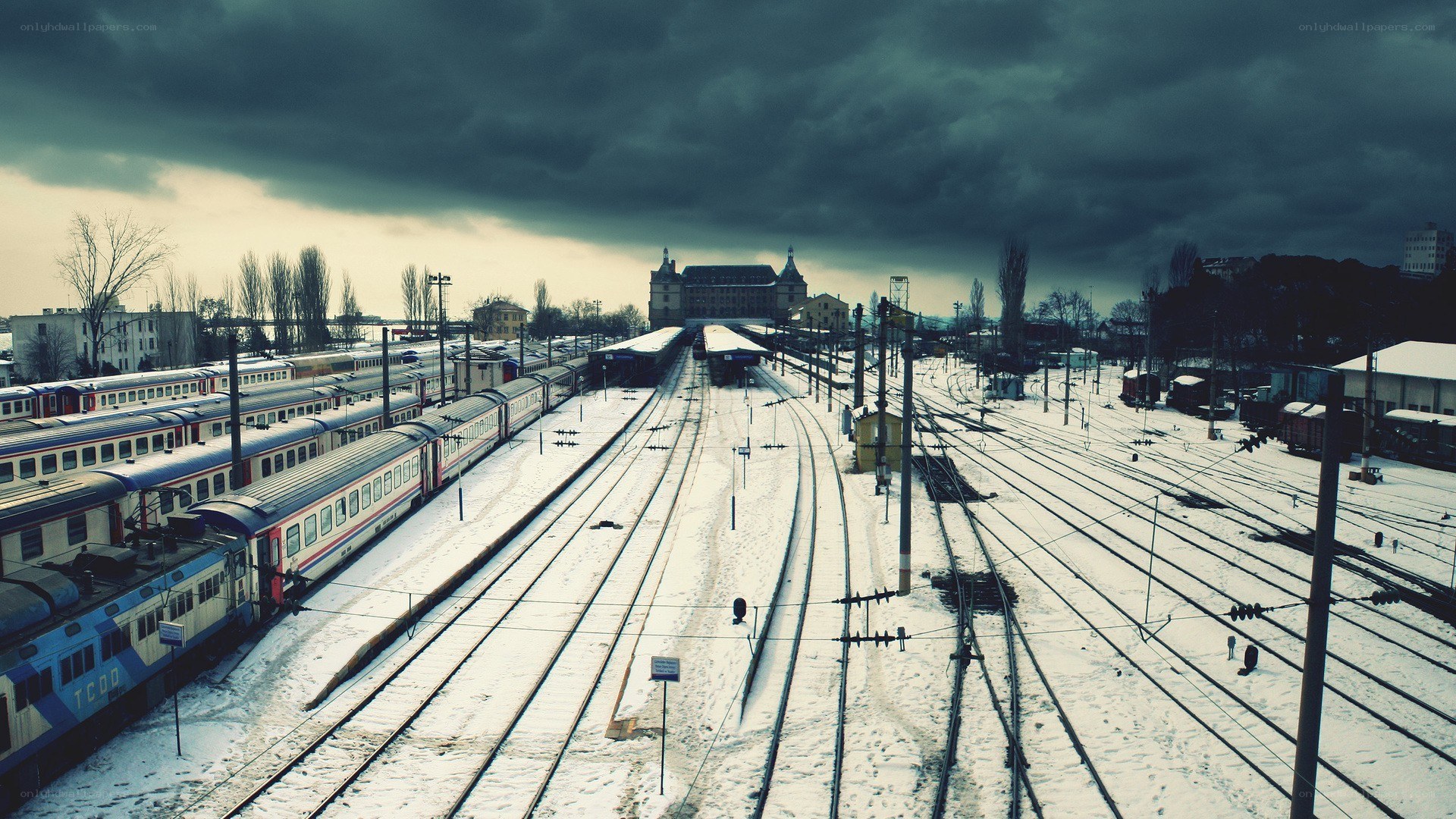 snowy train yard under storm clouds