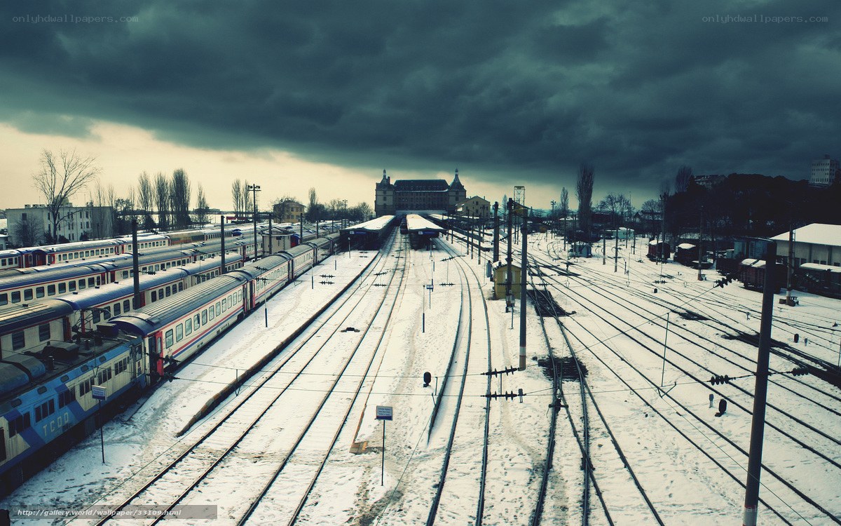 Snowy train yard under stormy sky