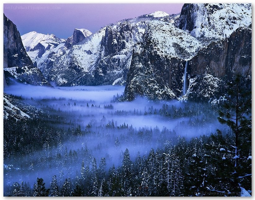 Snowy valley with mist and waterfall