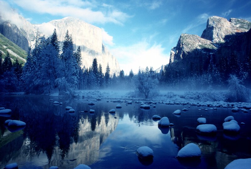 Snowy valley with river reflection