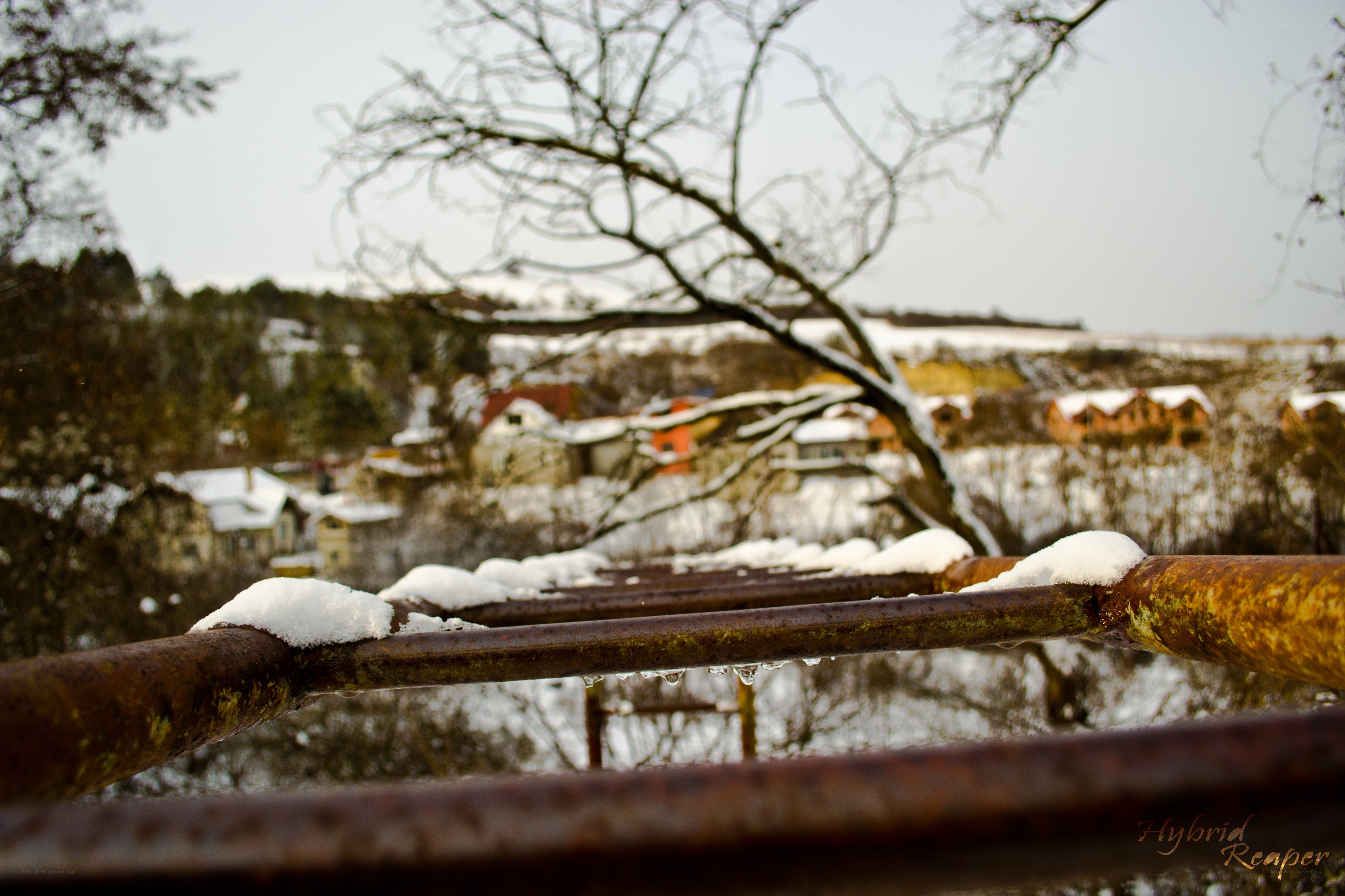 Snowy village from a rusty railing