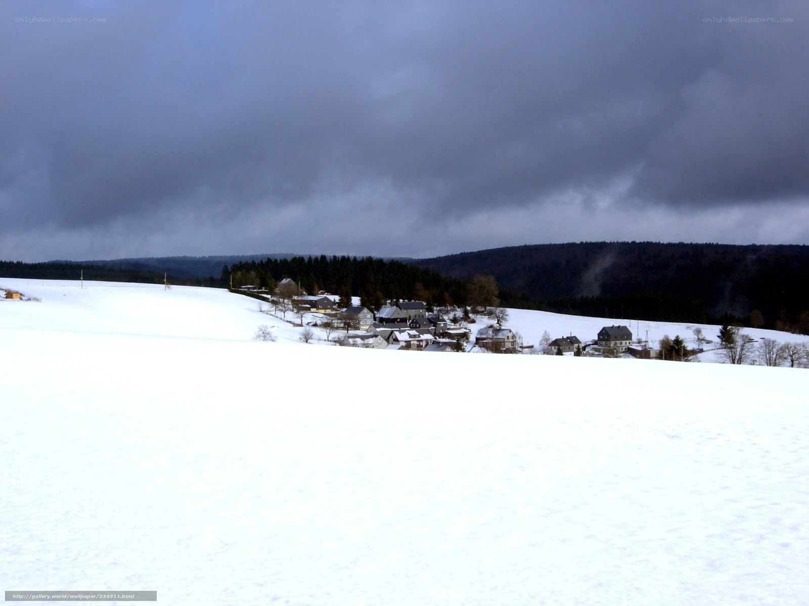 Snowy village under cloudy sky