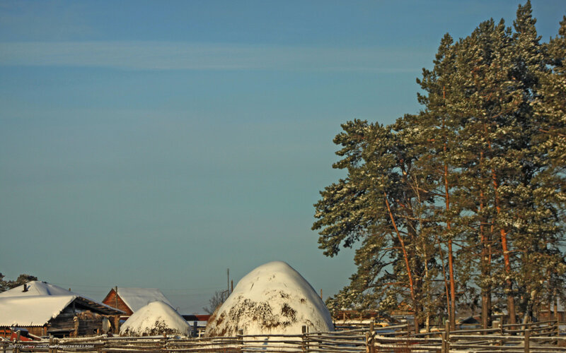 Snowy village with hay stacks