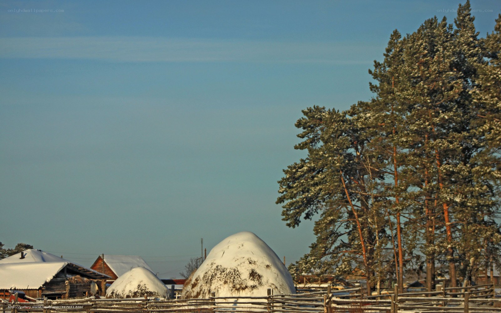Snowy village with hay stacks