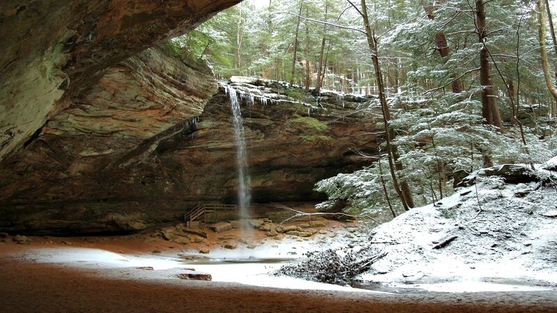 Snowy waterfall in forest cave