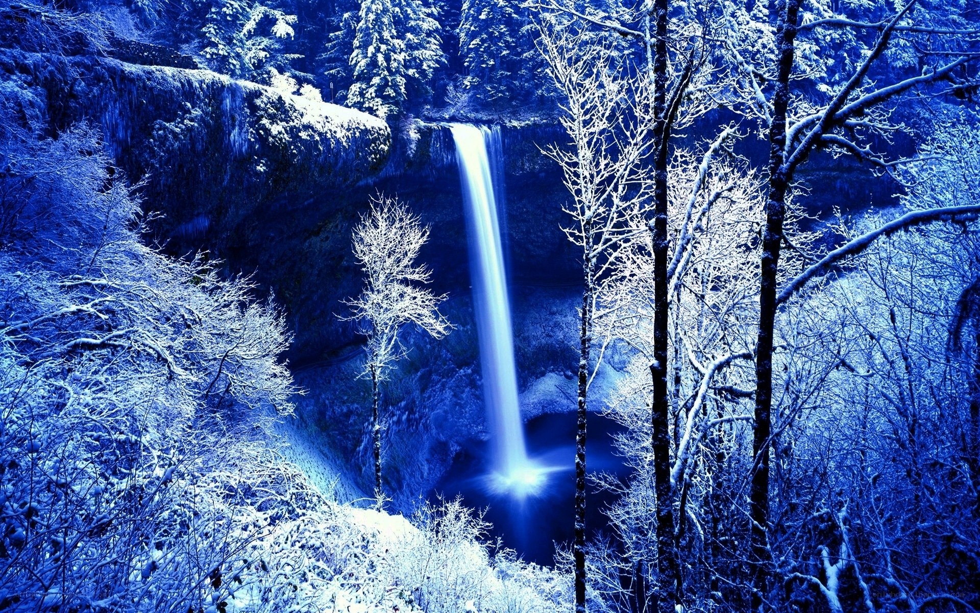 Snowy waterfall in winter forest