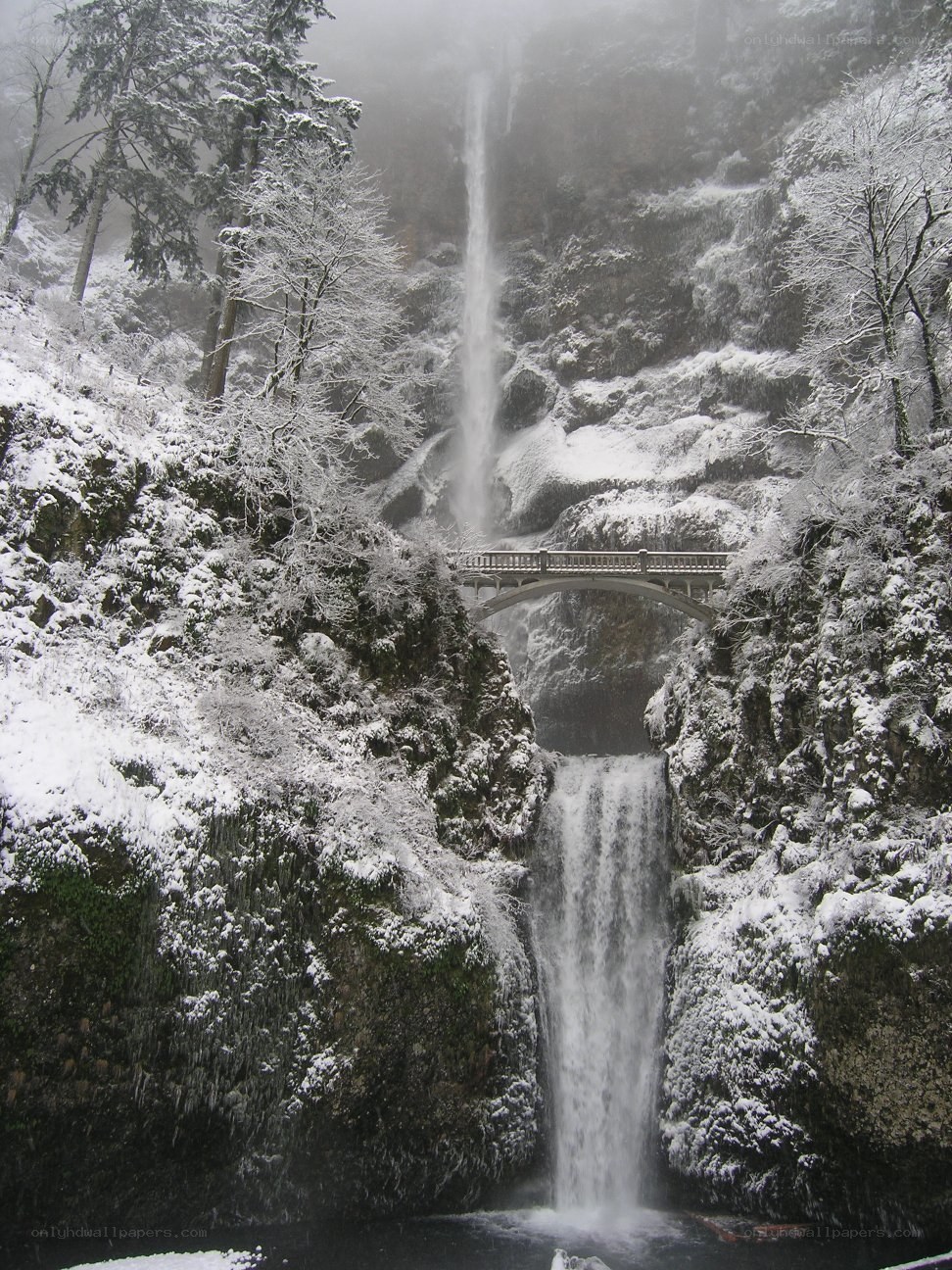 Snowy waterfall with bridge