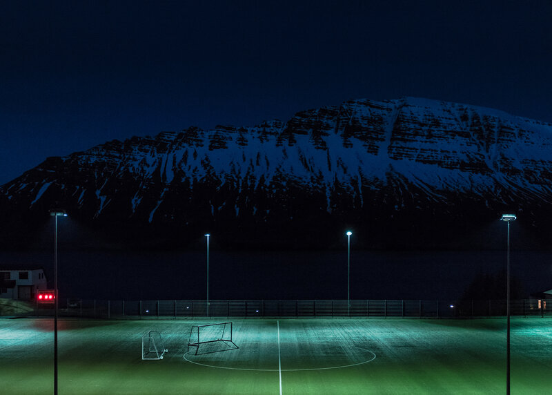 Soccer field at night with mountain