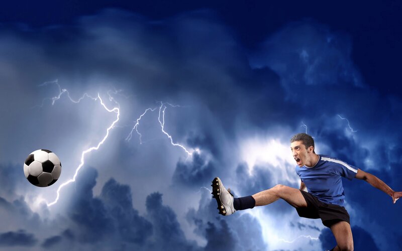 Soccer player kicking ball in storm