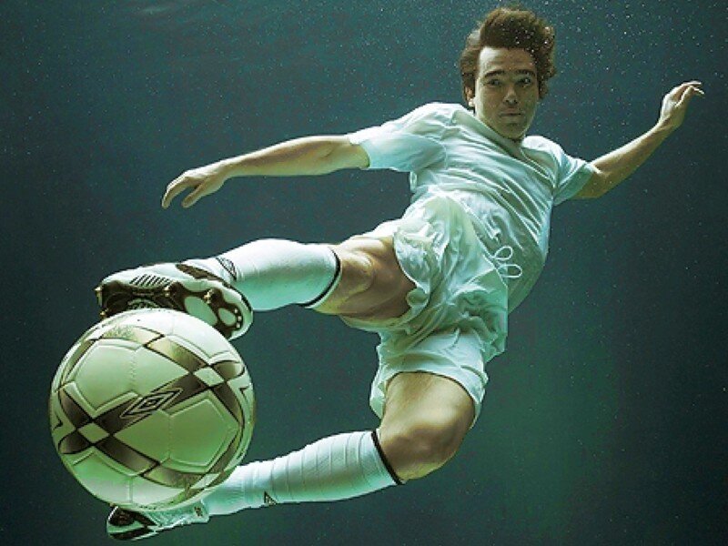 Soccer player kicking ball underwater