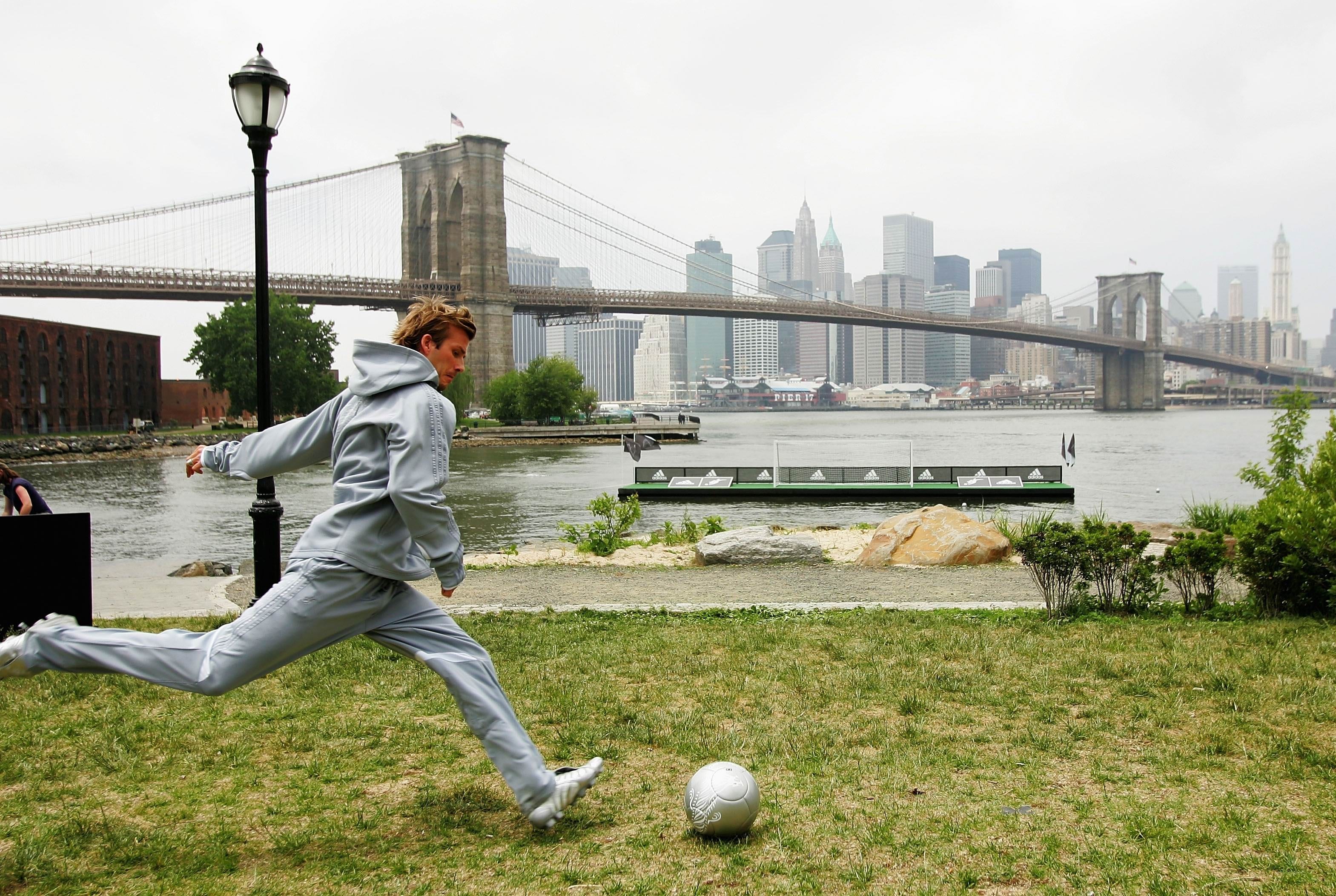 Soccer player on grass near bridge