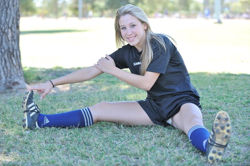 soccer player stretching on grass