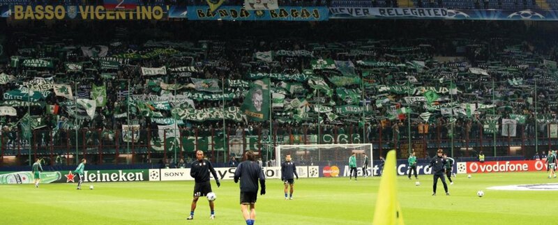 Soccer players on field with fans