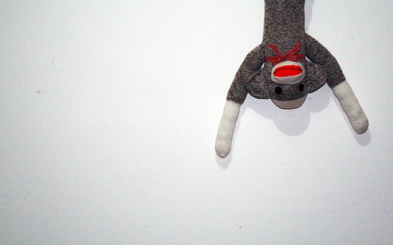 sock monkey hanging upside down