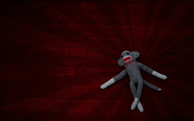 Sock monkey on red surface