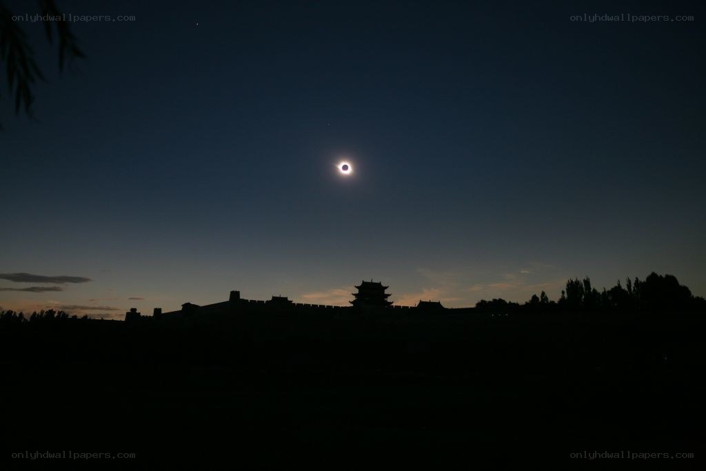 Solar eclipse over ancient wall